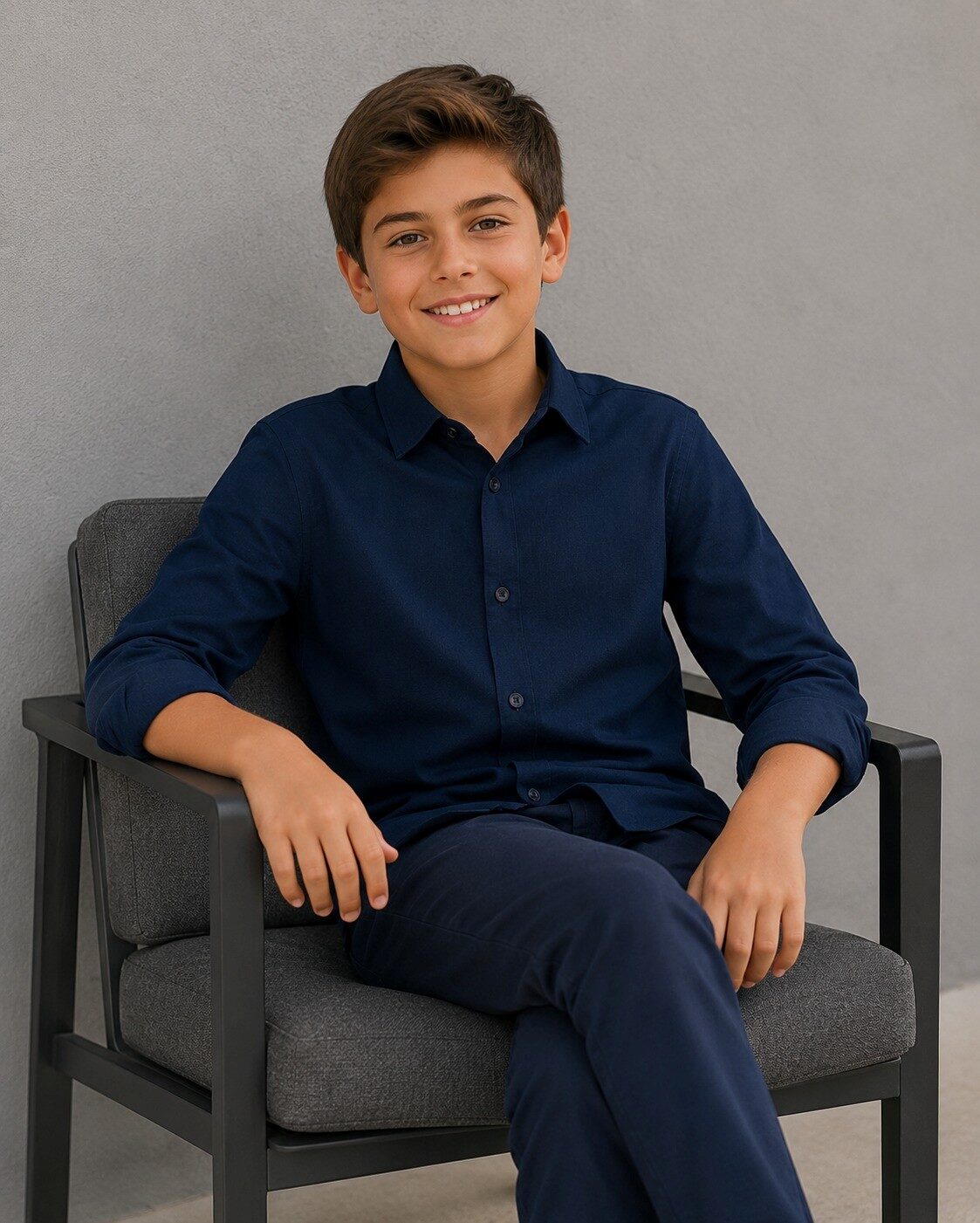 Boy seated in an Isaac Mizrahi navy shirt