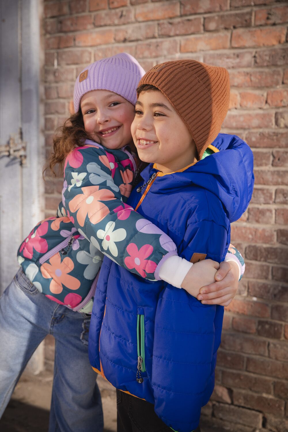 Two girls hugging in Deux par Deux coats