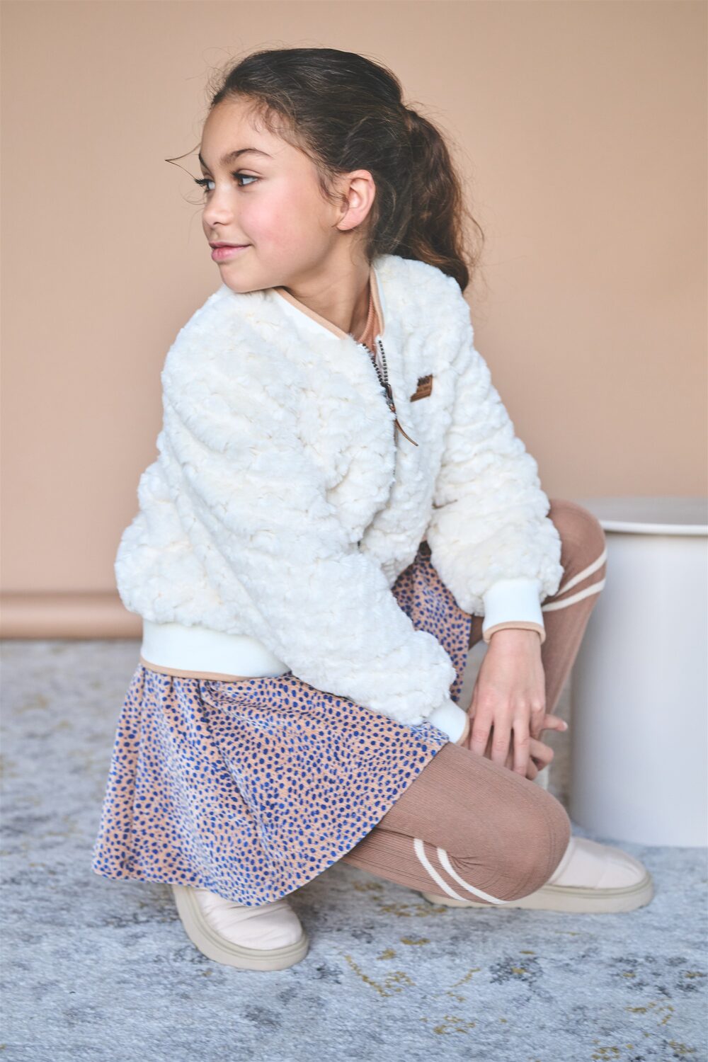 Girl in a NONO white fluffy sweater and floral skirt