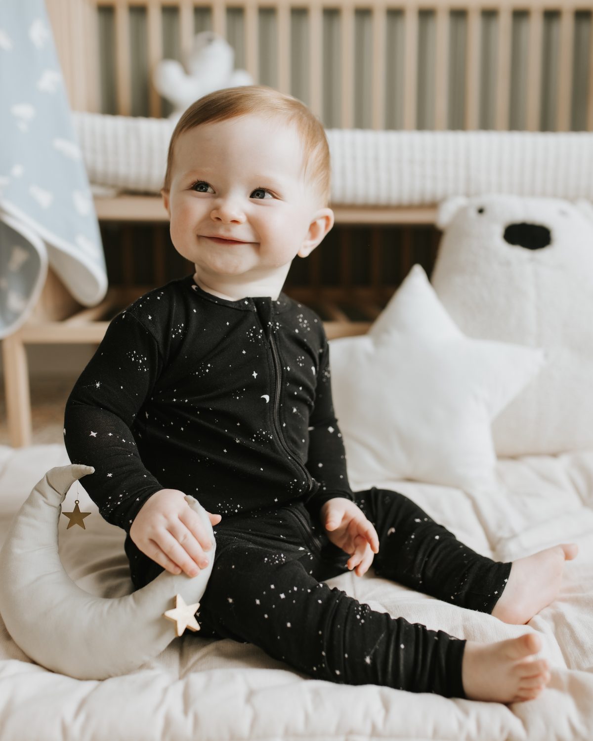 Baby in a Petit Lem black star-print sleeper